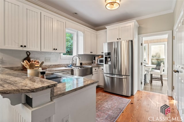 kitchen with stainless steel refrigerator with ice dispenser, light hardwood / wood-style flooring, kitchen peninsula, and white cabinetry