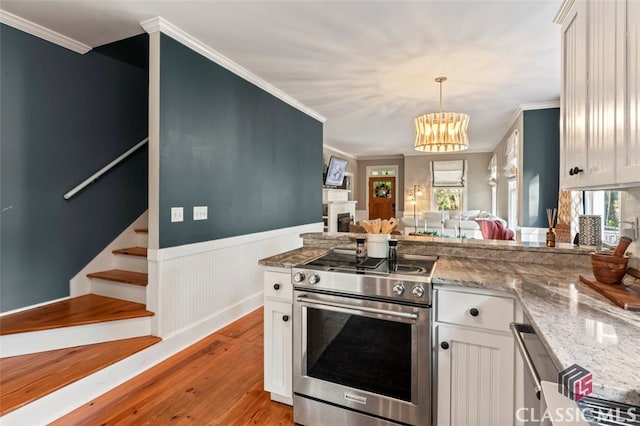 kitchen featuring white cabinetry, electric range, and a wealth of natural light