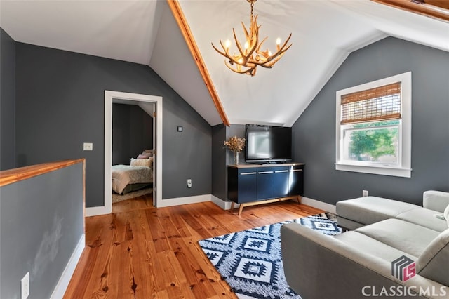 living room featuring an inviting chandelier, light wood-type flooring, and lofted ceiling