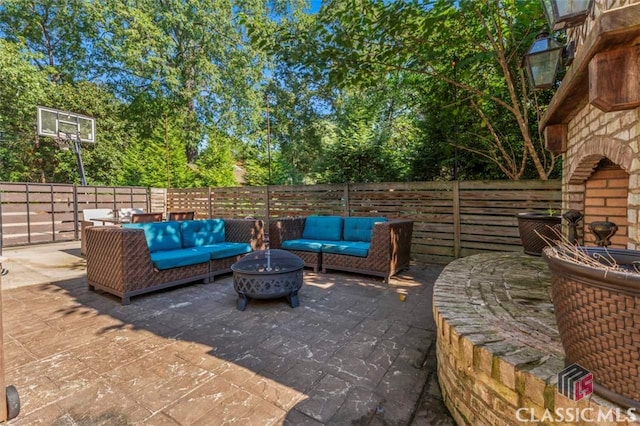 view of patio with an outdoor living space with a fire pit