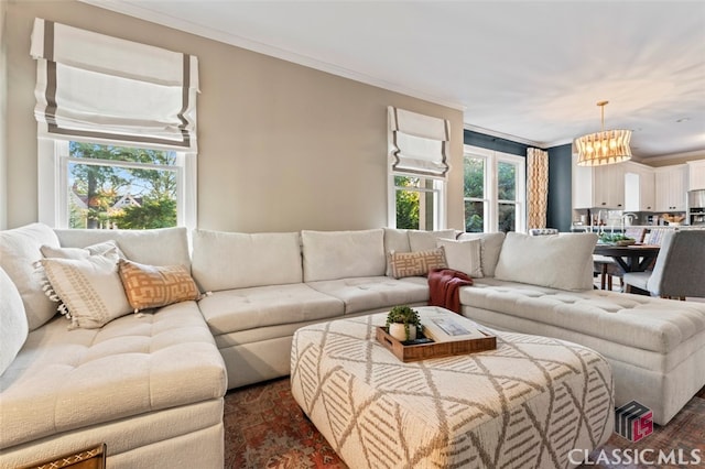 living room with an inviting chandelier and crown molding