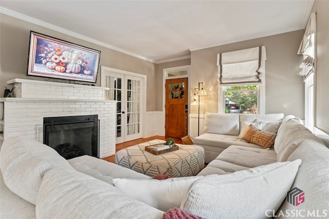 living room featuring ornamental molding, a brick fireplace, and hardwood / wood-style floors