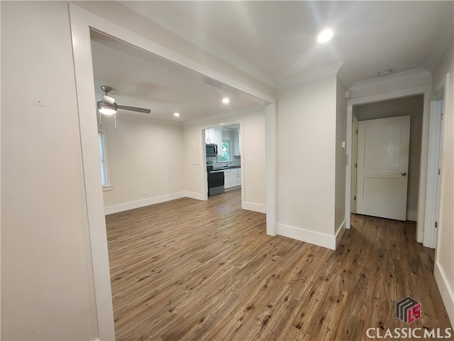 unfurnished living room featuring ornamental molding, ceiling fan, and hardwood / wood-style flooring