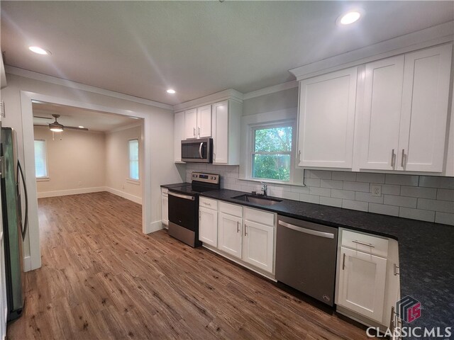 kitchen with white cabinetry, sink, light hardwood / wood-style flooring, and stainless steel appliances