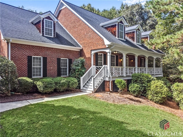 cape cod home featuring a porch and a front yard