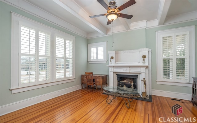 living area featuring ceiling fan, a tile fireplace, hardwood / wood-style floors, and a healthy amount of sunlight