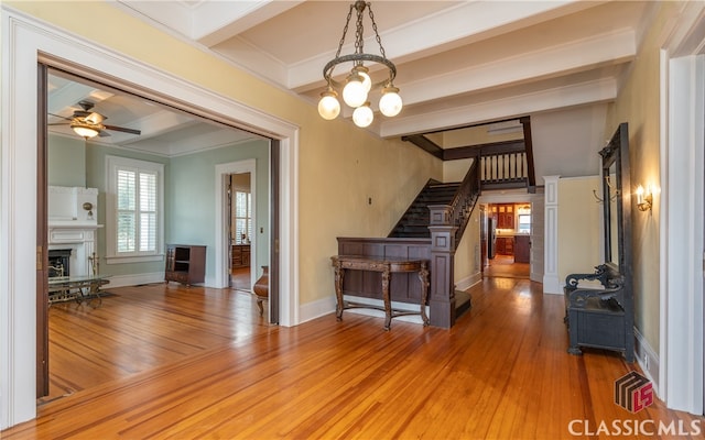 unfurnished living room featuring wood-type flooring, ornamental molding, and a wealth of natural light