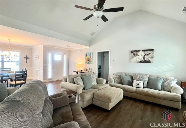 living room with ceiling fan with notable chandelier, dark hardwood / wood-style floors, vaulted ceiling, and crown molding