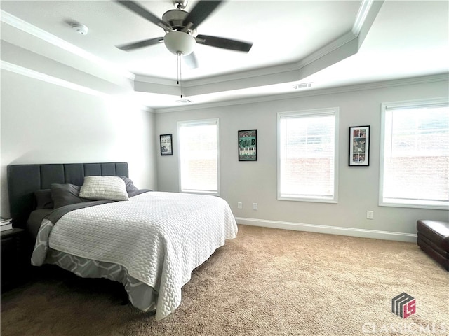 bedroom with a raised ceiling, ornamental molding, carpet, and ceiling fan