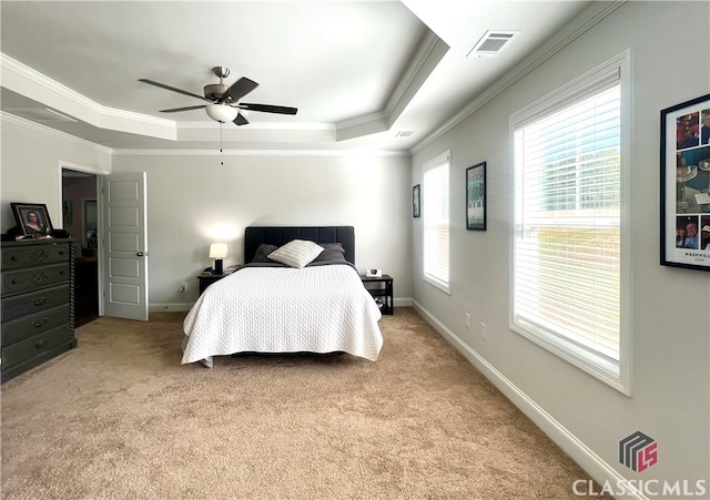 carpeted bedroom featuring crown molding, a raised ceiling, and ceiling fan