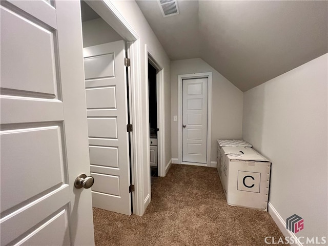 hallway featuring lofted ceiling and carpet flooring