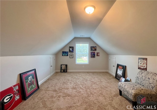 bonus room with vaulted ceiling and light colored carpet