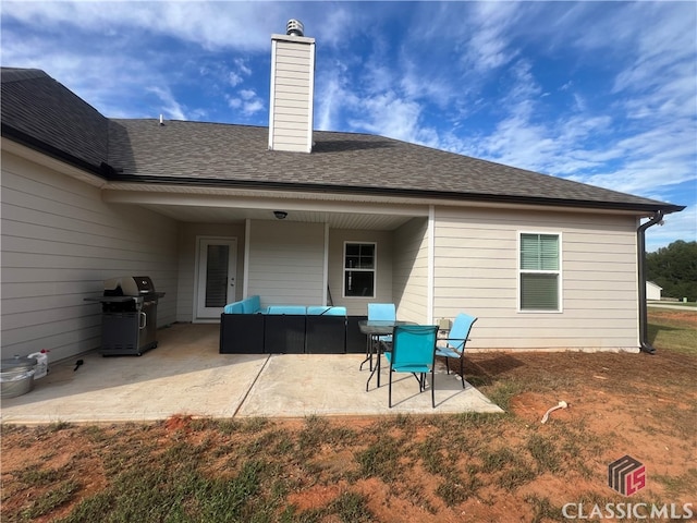 rear view of house with an outdoor living space and a patio area