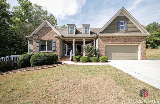 craftsman house featuring a front yard, a garage, and covered porch