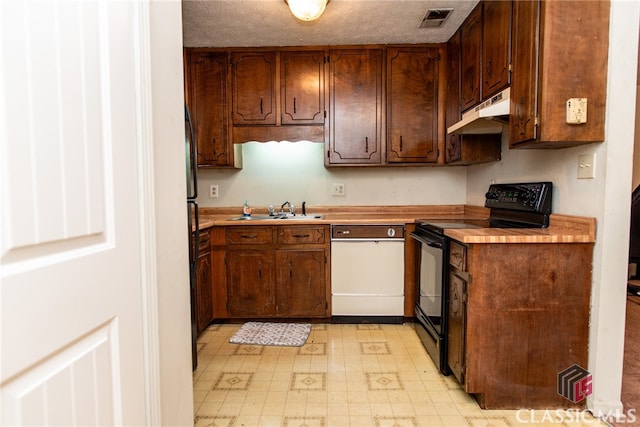 kitchen with black / electric stove, sink, butcher block counters, and a textured ceiling