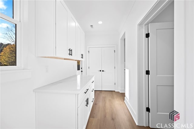 hall featuring light hardwood / wood-style flooring and crown molding