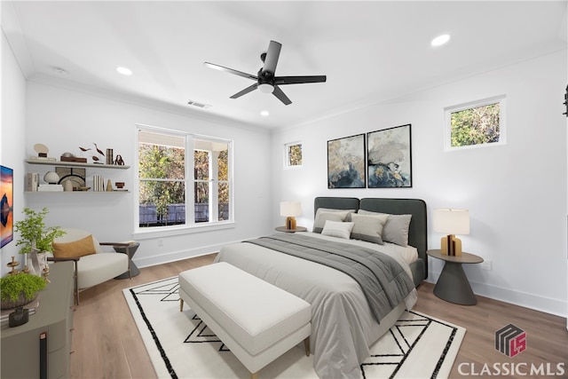 bedroom featuring ceiling fan, crown molding, and light hardwood / wood-style flooring