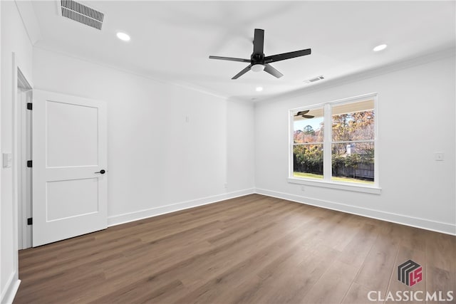 empty room with ceiling fan, crown molding, and dark wood-type flooring