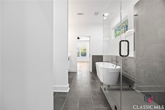 bathroom featuring ornamental molding, vanity, separate shower and tub, tile walls, and tile patterned flooring