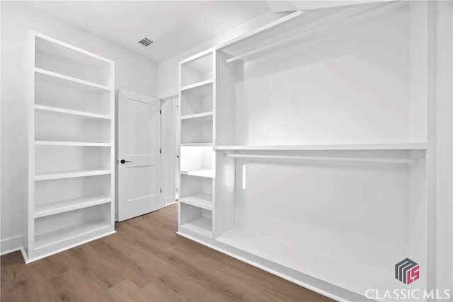 walk in closet with hardwood / wood-style flooring