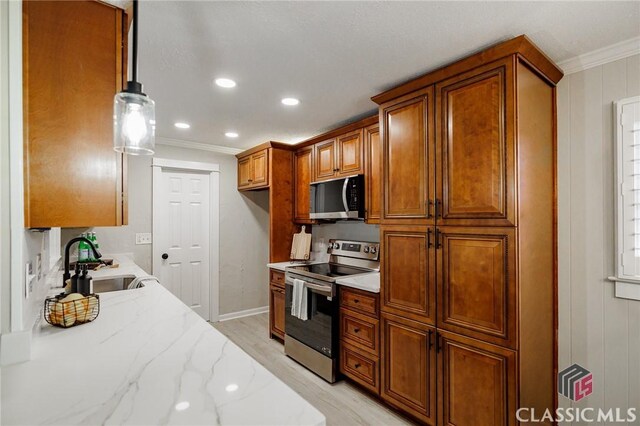 1471 Lenru Rd, Bogart, GA 30622 - kitchen with light wood-style flooring, crown molding, brown cabinets, stainless steel appliances, and a sink