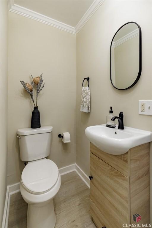 1471 Lenru Rd, Bogart, GA 30622 - bathroom with baseboards, toilet, crown molding, vanity, and wood finished floors