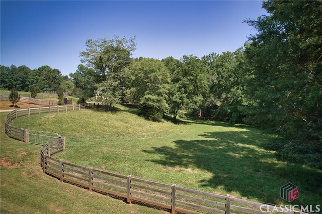view of yard with fence and a rural view