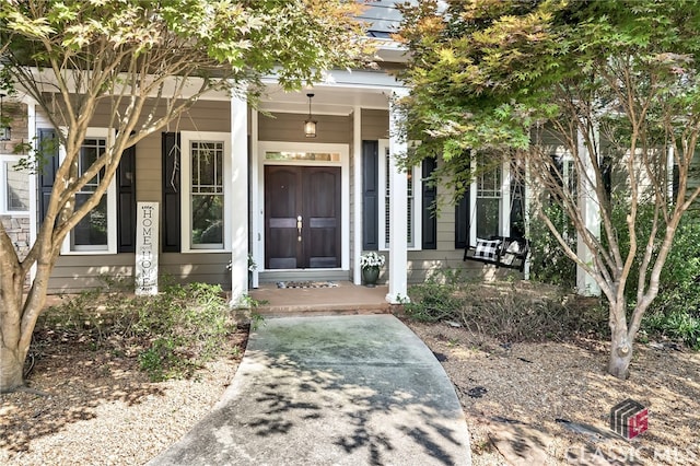 view of exterior entry featuring covered porch