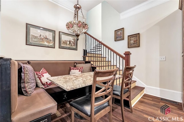 dining space featuring crown molding, stairway, visible vents, baseboards, and wood finished floors