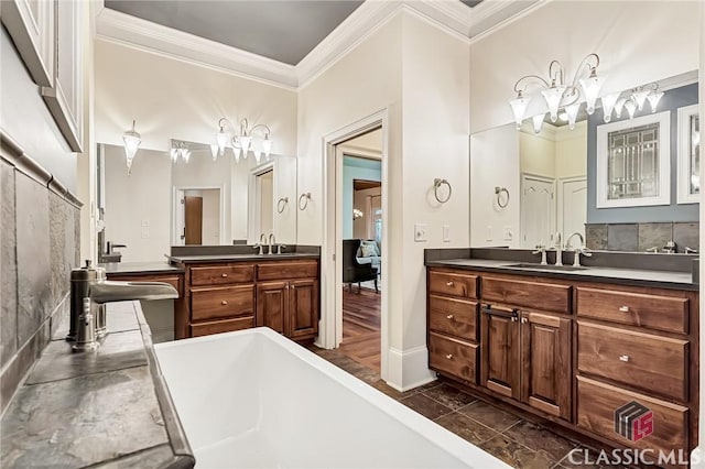 bathroom with two vanities, an inviting chandelier, crown molding, and a sink