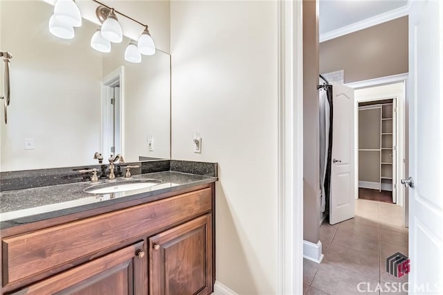 full bath featuring tile patterned floors, vanity, ornamental molding, and baseboards