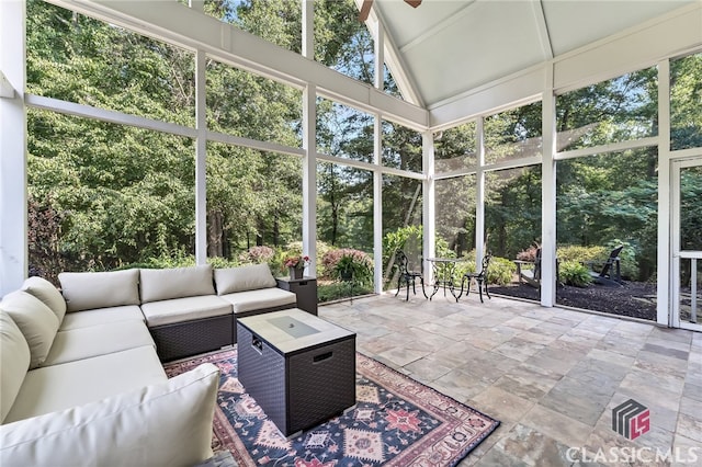 sunroom / solarium with ceiling fan and vaulted ceiling