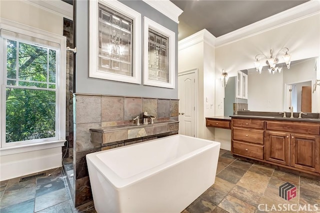 bathroom with a freestanding bath, stone finish floor, vanity, visible vents, and crown molding
