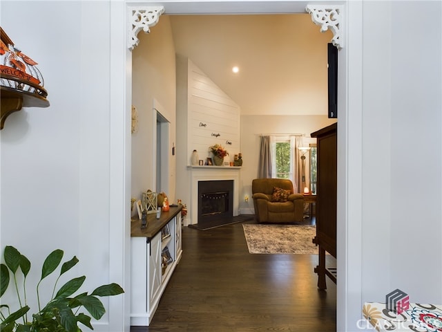 corridor with high vaulted ceiling and dark hardwood / wood-style flooring