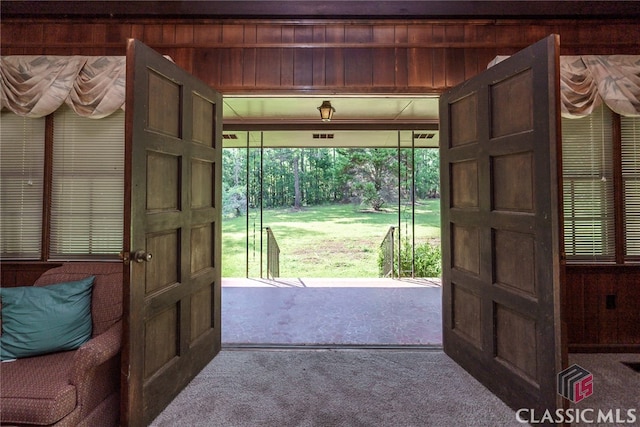 entryway with wooden walls and carpet flooring