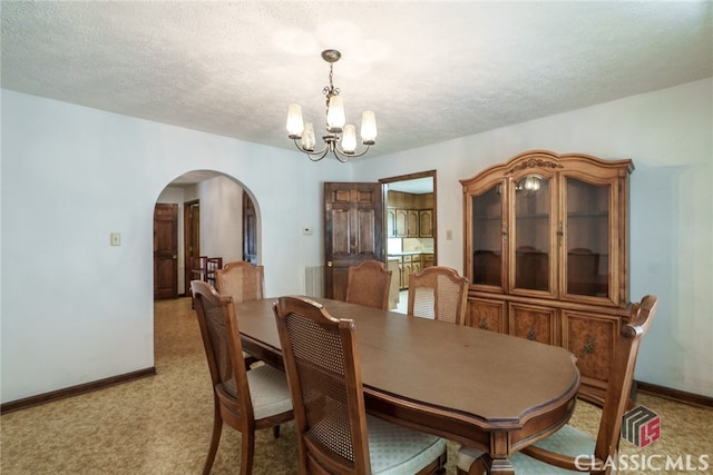 dining area featuring light carpet, a textured ceiling, and a chandelier