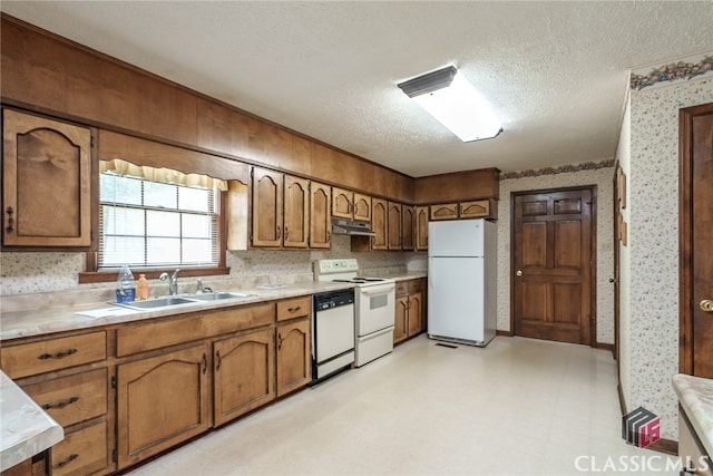 kitchen with a textured ceiling, sink, and white appliances