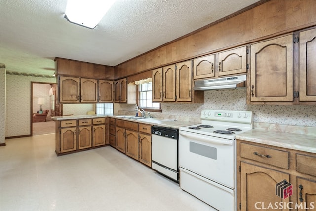 kitchen with white appliances, sink, kitchen peninsula, and a textured ceiling