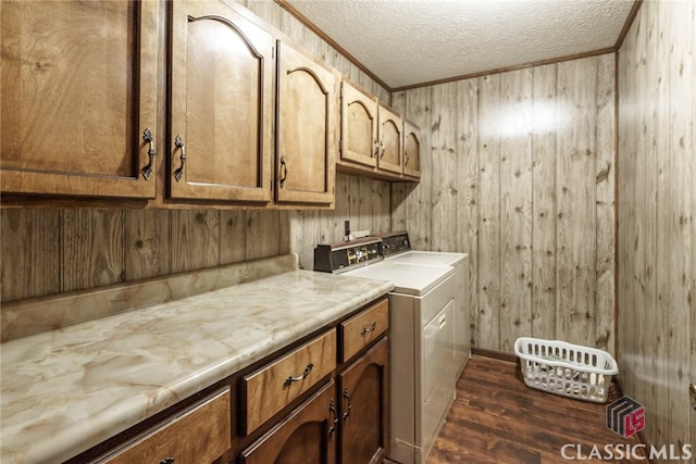 washroom with washer and clothes dryer, dark wood-type flooring, cabinets, wood walls, and a textured ceiling