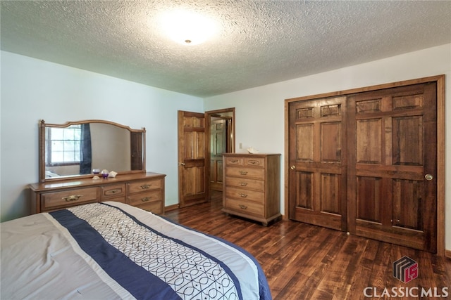 bedroom featuring dark wood-type flooring, a closet, and a textured ceiling