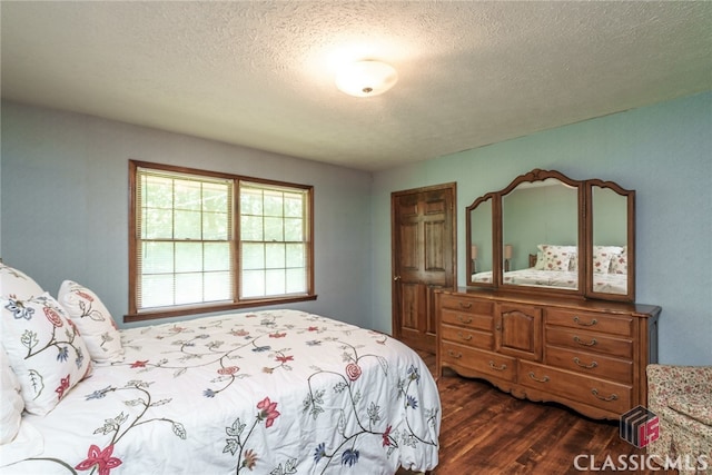 bedroom with dark hardwood / wood-style floors and a textured ceiling