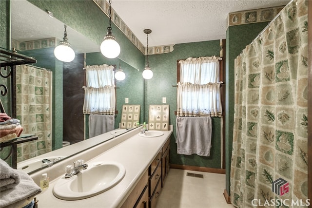 bathroom featuring walk in shower, vanity, and a textured ceiling