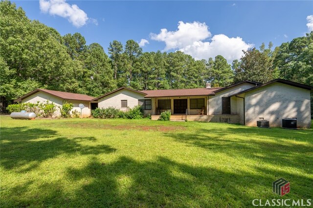 view of front of property with a front lawn and central AC unit