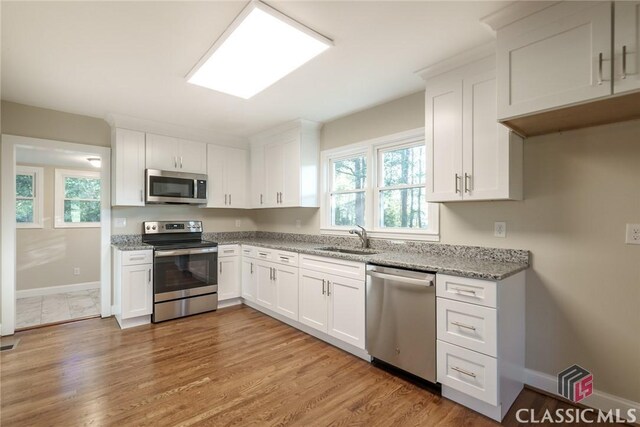 218 E Vine St, Monroe, GA 30655 - kitchen featuring a sink, a wealth of natural light, appliances with stainless steel finishes, and light stone counters