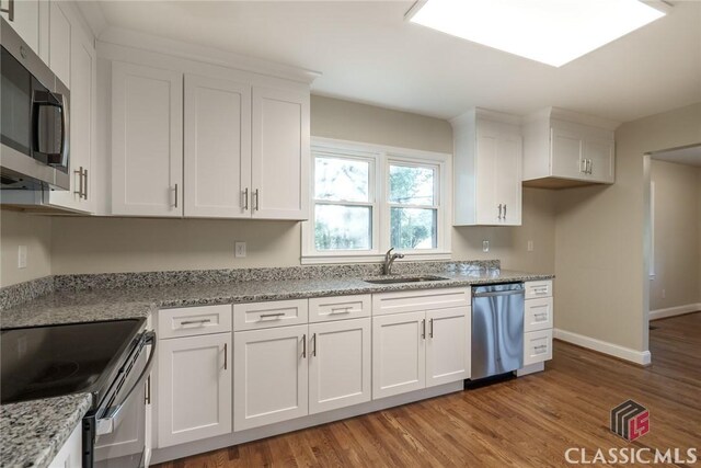 218 E Vine St, Monroe, GA 30655 - kitchen with light wood-type flooring, white cabinetry, and stainless steel appliances