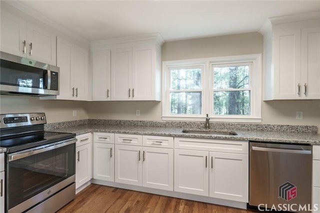 218 E Vine St, Monroe, GA 30655 - kitchen with a sink, white cabinets, appliances with stainless steel finishes, and wood finished floors