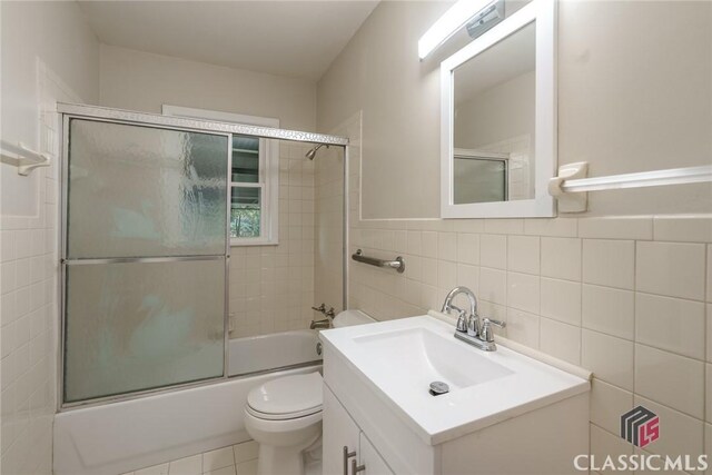 218 E Vine St, Monroe, GA 30655 - bathroom with toilet, tile walls, combined bath / shower with glass door, and vanity