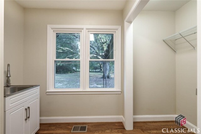 218 E Vine St, Monroe, GA 30655 - interior space with baseboards, dark wood-style flooring, a sink, and visible vents