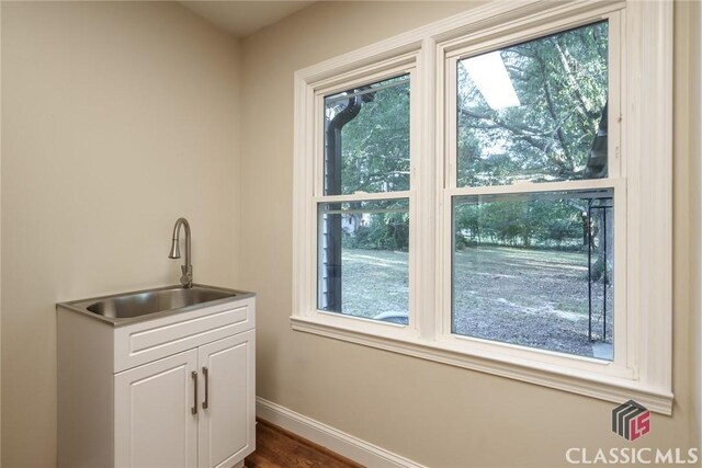218 E Vine St, Monroe, GA 30655 - clothes washing area with dark wood-style flooring, baseboards, a sink, and cabinet space