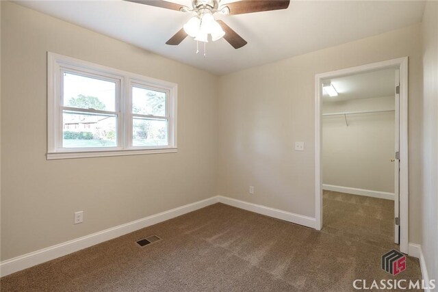 218 E Vine St, Monroe, GA 30655 - unfurnished bedroom with a spacious closet, visible vents, baseboards, and carpet floors